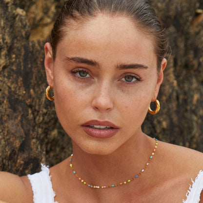Colar delicado de arco-íris da marca Mari Gavane, estilo chokers, com design colorido e minimalista em imagem bem iluminada.