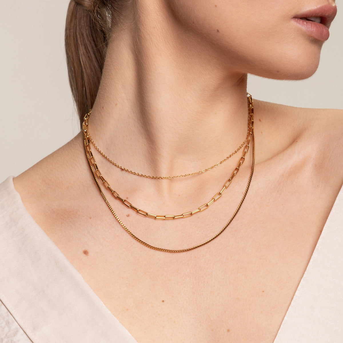 Colar em camadas da marca Mari Gavane com três fios dourados, estilo elegante e moderno, para looks sofisticados.